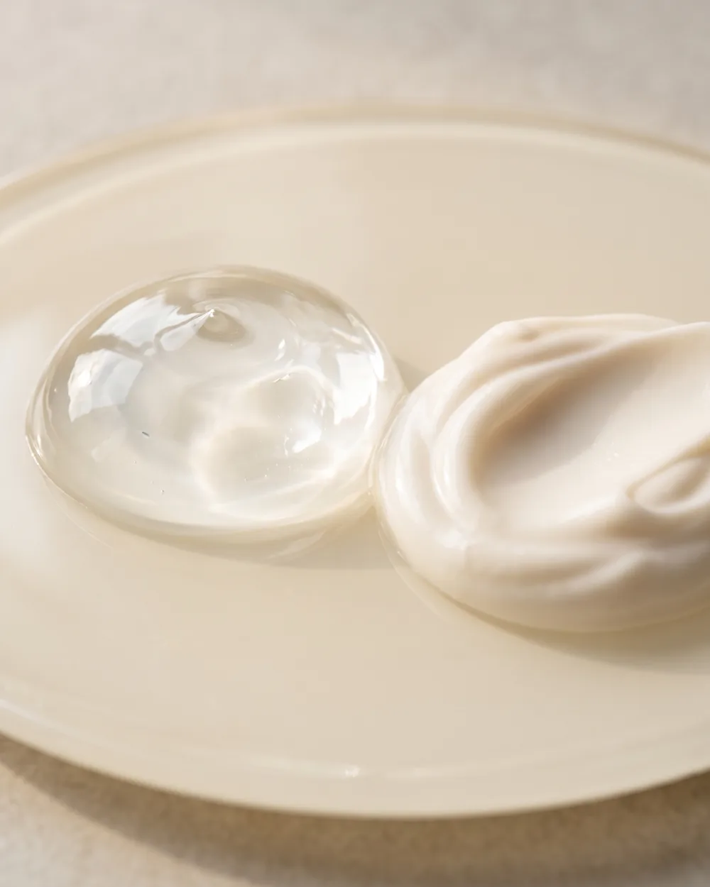 Klar, blank gel og mat hvid creme side om side på en lys glasplade